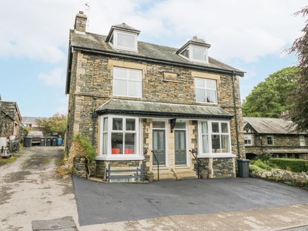 A stone exterior semi detached house with two front doors and a driveway at Park Beck 3 in Windermere