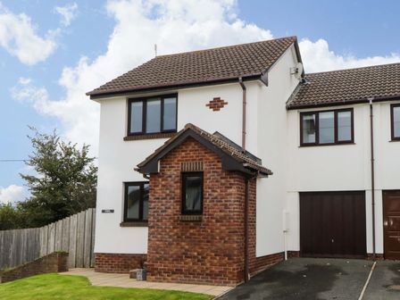 A semi detached house with a garage and driveway at Croyde Pebbles in Croyde