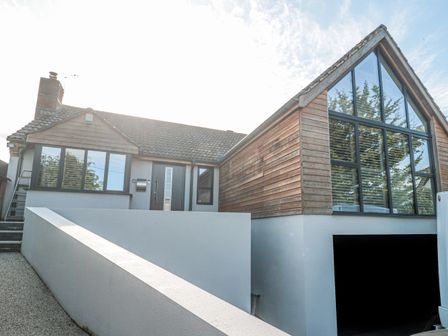 A house with a wooden and tiled roof exterior and a large glass window at Orchard Leigh in North Petherton