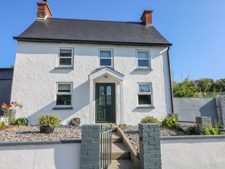 Front view of a white two-story house with a green door and six windows at An Teach Ban in Bunclody County Wexford