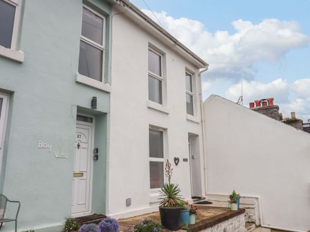 Front view of two adjoining houses with plants in pots near entrances at The White House in Brixham