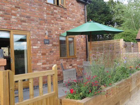An outdoor area with a table and chairs at The Cartshed in Defford