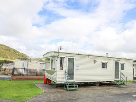 A static caravan with two porches on a lawn at D12 Treetops Clarach near Aberystwyth