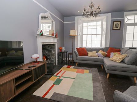 A living room with a sofa and television at Unicorn Cottage