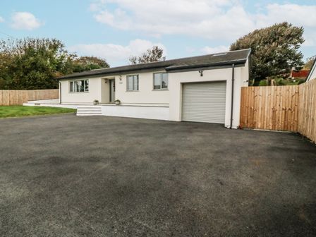 A house with a garage and driveway at Tyn Y Coed in 