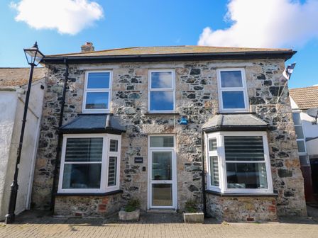 Stone exterior house with two bay windows and four upper windows at Savoy View in Mullion