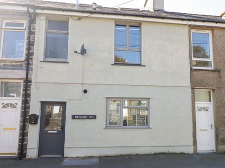 A terrace house with two windows a dark door and a mailbox at Hendre 145 in Blaenau Ffestiniog