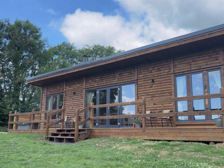 A log cabin with a wooden deck at Foxglove in Higher Wambrook near Chard