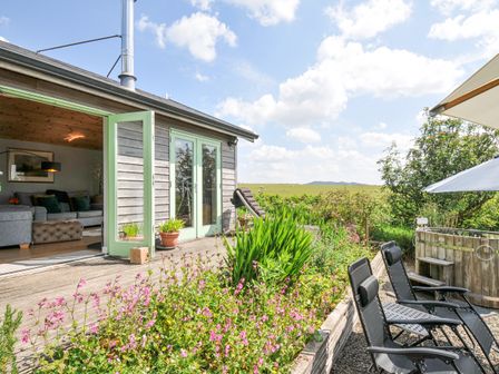 An outdoor area with seating and flowers at Smugglers Bodmin Moor, St Breward near St Tudy