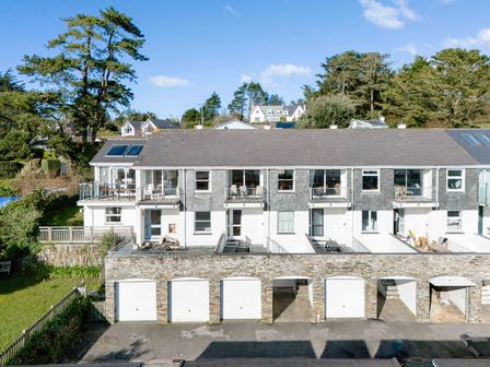 A row of houses with garages below and balconies above surrounded by trees at Slipway 14 in Rock