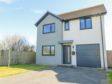 A modern two-story house with a driveway garage and small front lawn at 6 Gwel Yr Wyddfa Llanfaelog near Rhosneigr