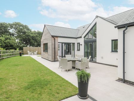 An outdoor patio area with seating and a garden at Kerrek Lodge Mylor Bridge
