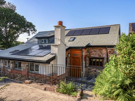 A house with solar panels and a chimney at Heathmoor in Horrabridge