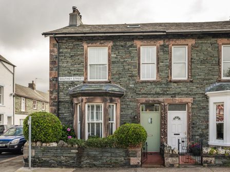 Stone exterior of a two-story house with a green door white door and bay window on Southey Street