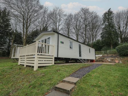 A mobile home with steps and decking in an outdoor area at Woodlands Platinum (WO29) in Ruthin