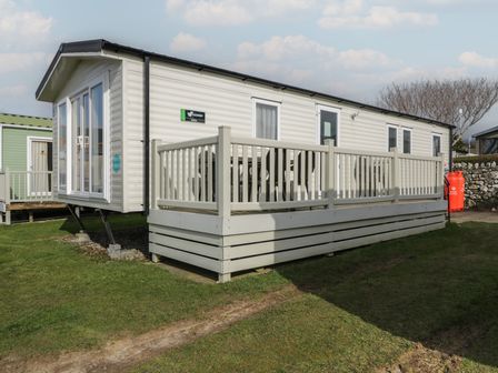 A caravan with a deck and outdoor seating at Gold Caravan (203) Talybont