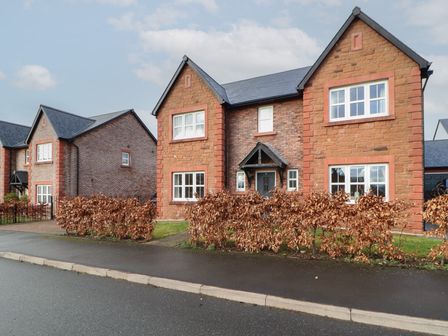 A residential street with two brick houses and hedges along the sidewalk at 4 Centurion Rise in Penrith