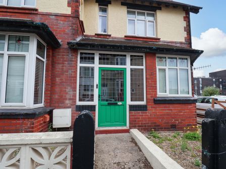 A front entrance with a green door and brick facade at Falcon's Nest in Whitby