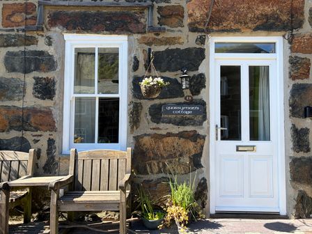 A door and window with a sign at Quarryman's cottage in Beddgelert