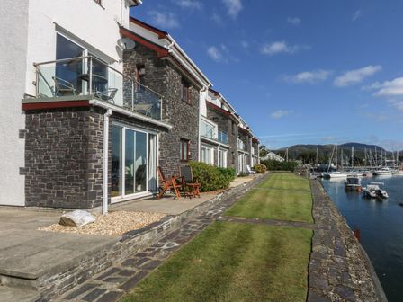 An outdoor area with buildings, grass, and boats at 1 Oakley Wharf Porthmadog