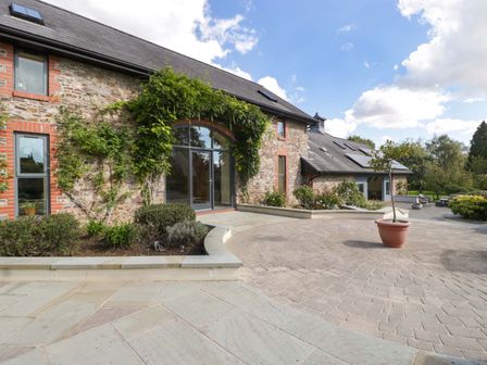 An outdoor area with a stone building and plants at Heathcliffe House in Castleton near Cardiff