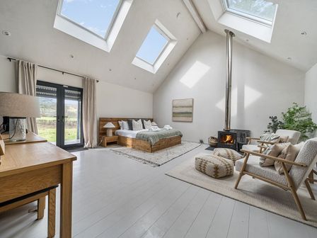 A bedroom with a bed and fireplace at Grove Cottage in Gladestry