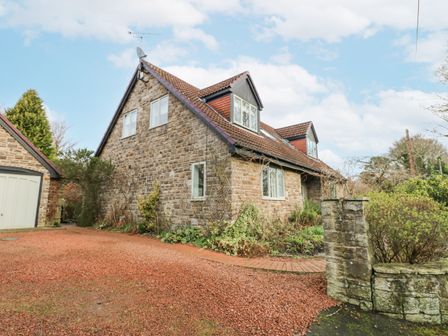 A stone house with a tiled roof and a gravel driveway at Kerangarth in Corbridge