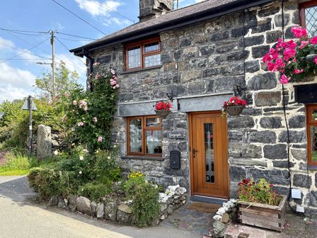 The entrance of Gwynfa with flowers and stone features in Ysbyty Ifan
