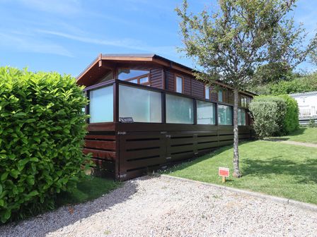 A wooden house with glass panels in an outdoor area at Skyview in Newton Ferrers