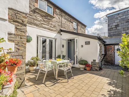 An outdoor dining area with a table and chairs at Mews Cottage Tintagel