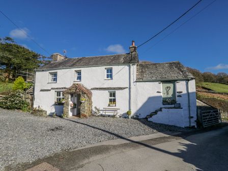 A cottage with a gravel pathway and garden at High Ickenthwaite Farmhouse in Ulverston