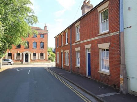 A street view with brick buildings and a parked car near The Townhouse in Salisbury