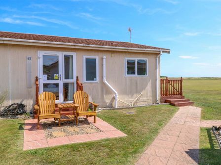 A house with adirondack chairs in front at Boa Vista in Bacton
