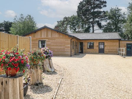 An outdoor view of a wooden building with flower planters at Barn Owl Lodge