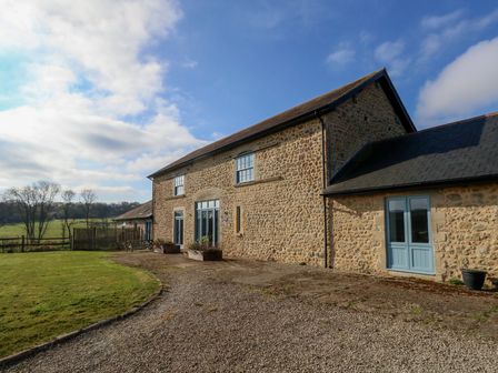 A stone farmhouse with blue doors and windows beside a gravel driveway and lawn at Stapleford Farm Hooke near Beaminster