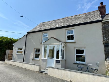 A house with a front porch and seating area at Glendale Trelights near Port Isaac