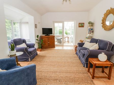 A living room with sofas and a television at Llain in Cardigan