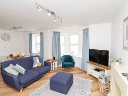 A living room with a sofa, chair, and television at Belle's View in Scarborough