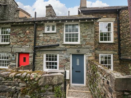 A stone exterior with a blue door and red door at Dove Cottage Ambleside