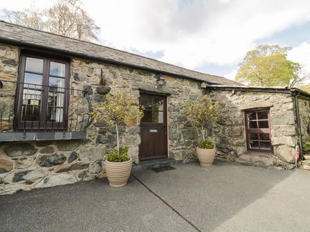 An exterior view of a stone property with planters at Cyffdy Cottage - Arenig in Bala