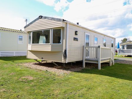 A beige mobile home with a small porch on a grassy plot at 4 Foxburrow Hang in Fritton near Belton Norfolk