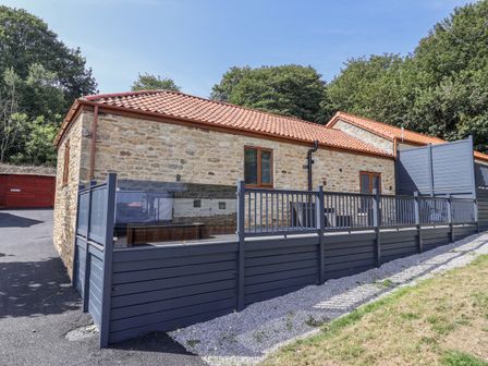 A house with stone exterior and deck at Birch Cottage in Scarborough