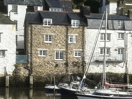 Houses by the marina with boats in the water at Harbour View Polperro