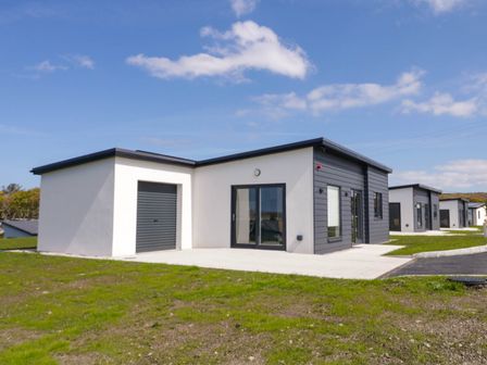 A row of modern single-story houses with garages and paved driveways at Number 3 Villa - The View in Derrybeg County Donegal