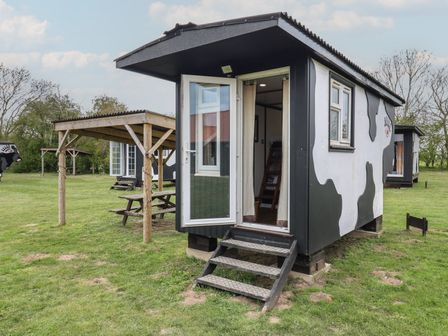 An outdoor area with a cow shed and seating at Molly (Cow Shed 6) Woodbridge