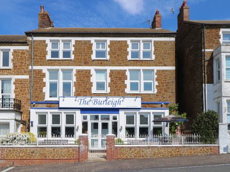 A three story brick building with white trimmed windows and a sign reading The Burleigh in Hunstanton