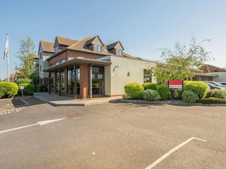 An exterior view of a building with a parking lot at Marine Court First-floor Double Bedroom with Bathroom in Littlehampton