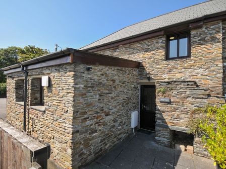 A stone exterior of a house with a door at Norvys in Bossiney