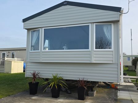 A mobile home with planters outside at Pines 15 Porthcawl