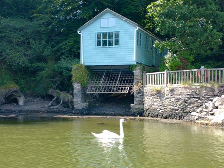 A house on stilts beside water at The Sharpham Boat House in Ashprington